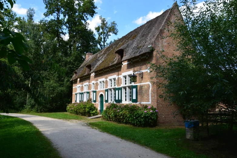 a brick house that has several large windows