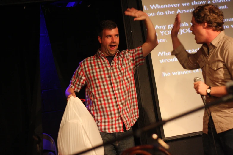 two men standing in front of a screen giving a presentation