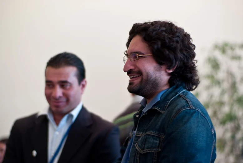 a man smiling at another man sitting next to him