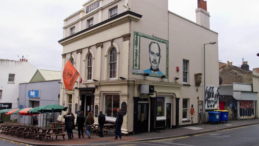 several people standing outside of a store front in an old town