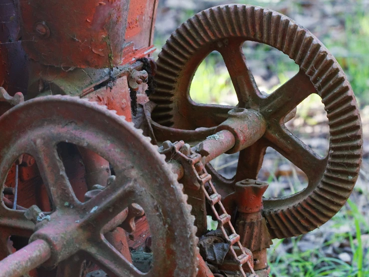 an old rusted mechanical train car wheel