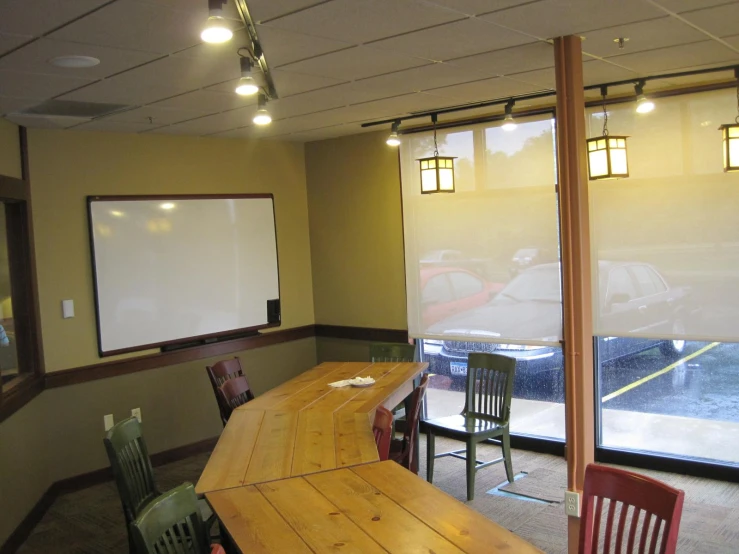 large meeting room with table and chairs, and an empty projection screen