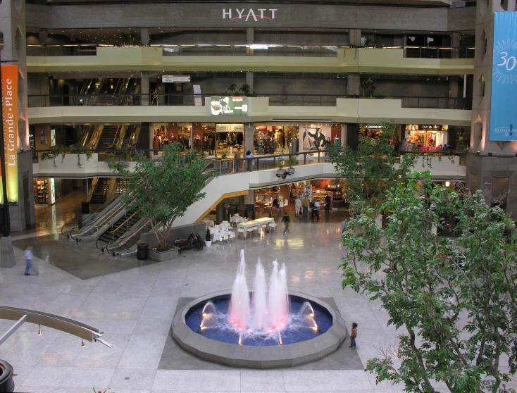a fountain in a lobby filled with people and shopping