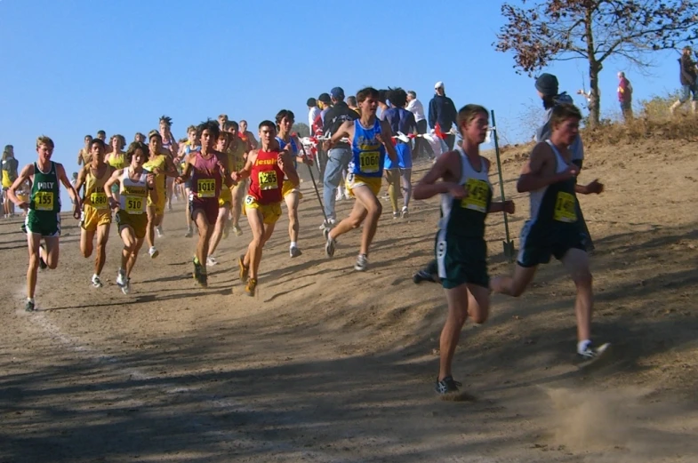many people running down a hill as a crowd watches