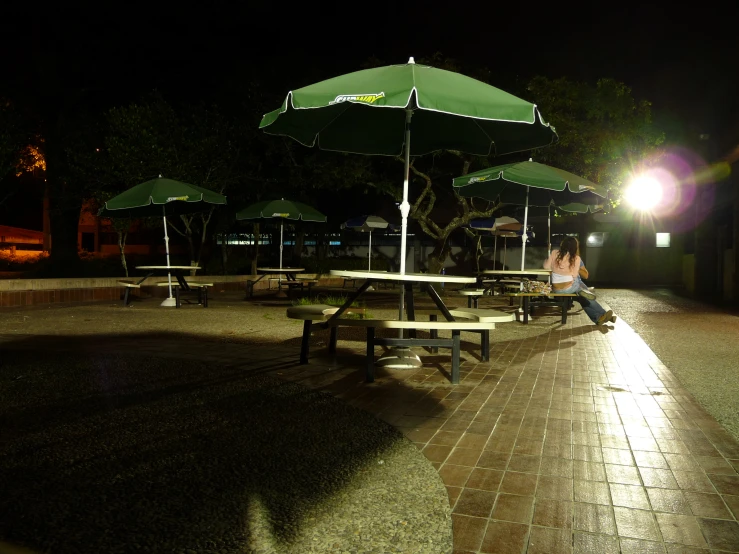 people sit at the tables and umbrellas outside