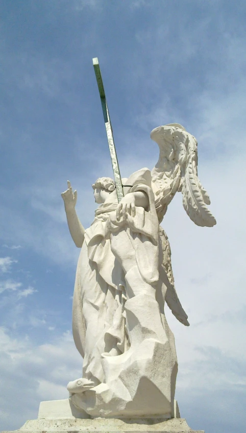 a white statue of a saint michael with a sword