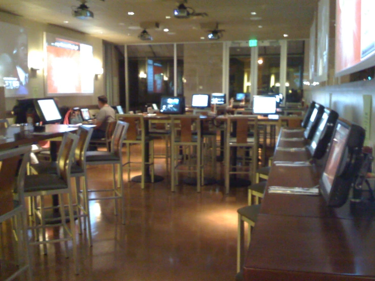 a restaurant filled with lots of computers next to people