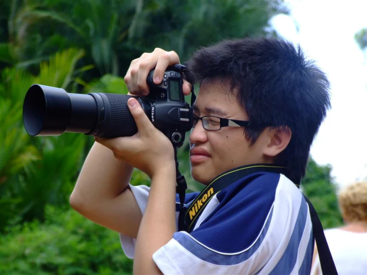 a young man with glasses holding a camera