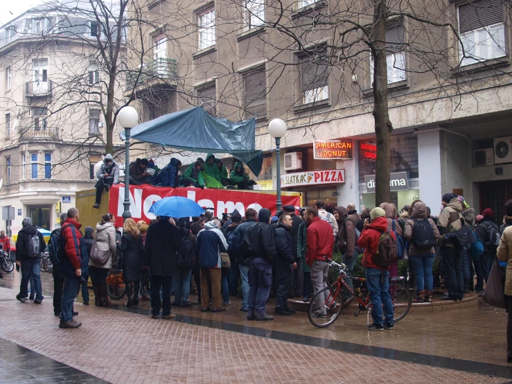 the crowd is lined up with an open top tour bus