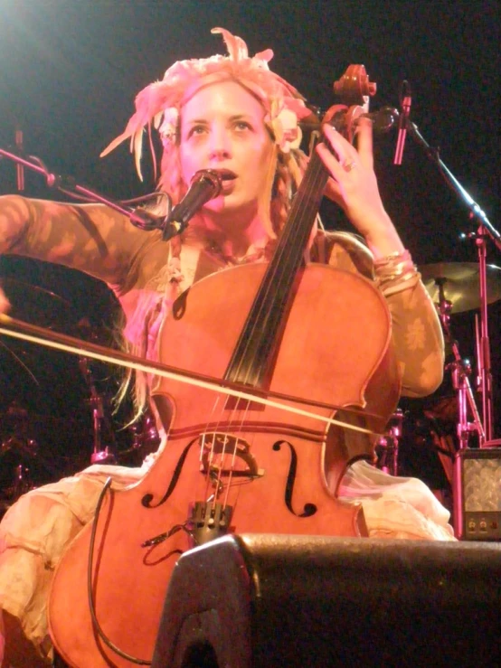 a woman playing an instrument on stage with microphone