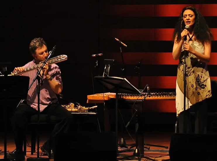 two musicians performing on stage with one singing into a microphone