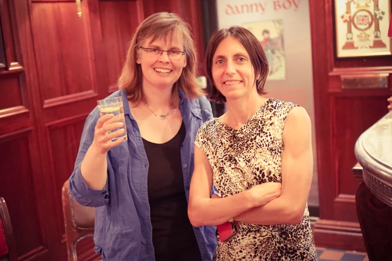 two women standing together posing for a po