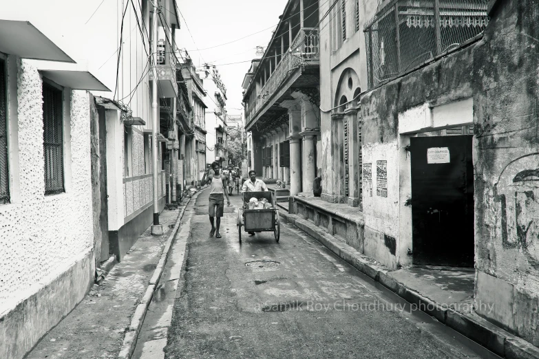 a horse drawn wagon on a road next to buildings