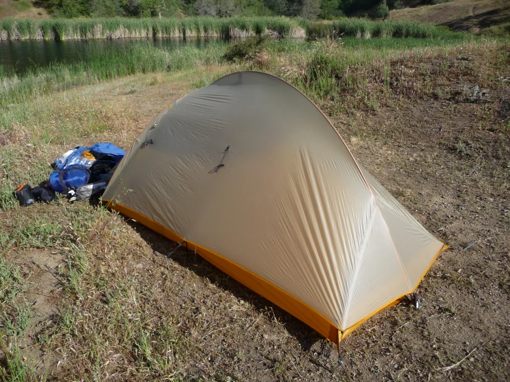 a tent is resting on a dry grass field