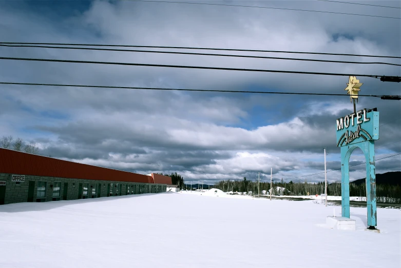 a large field covered in snow under a cloudy blue sky