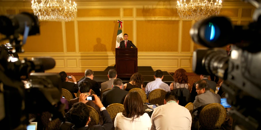 several people watching a speaker in a conference room