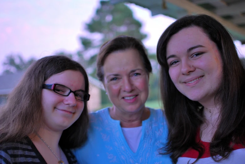 three women smiling while posing for the camera