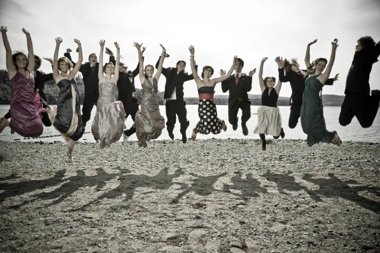 a group of people leaping on the beach