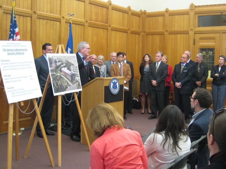 a group of people standing around a podium in a room