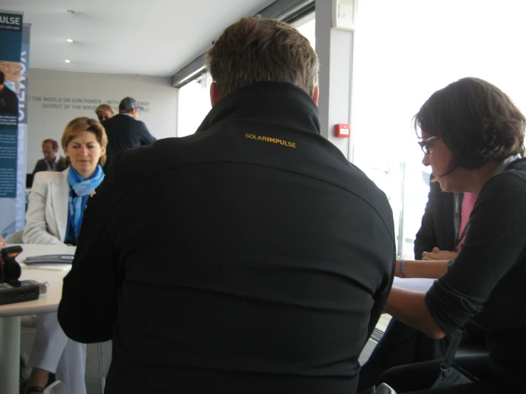 a business woman and man sitting at desk discussing soing