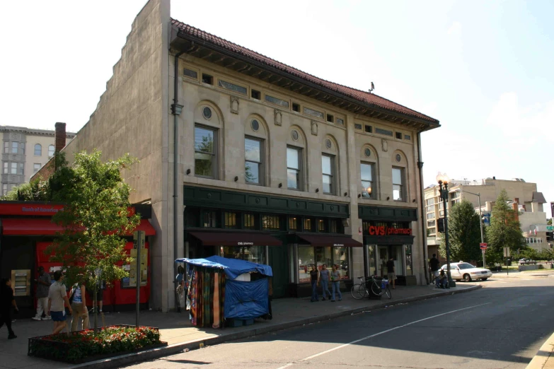 a building next to the road has lots of small businesses on the corner