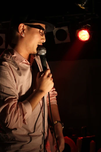 man wearing a hat singing into a microphone
