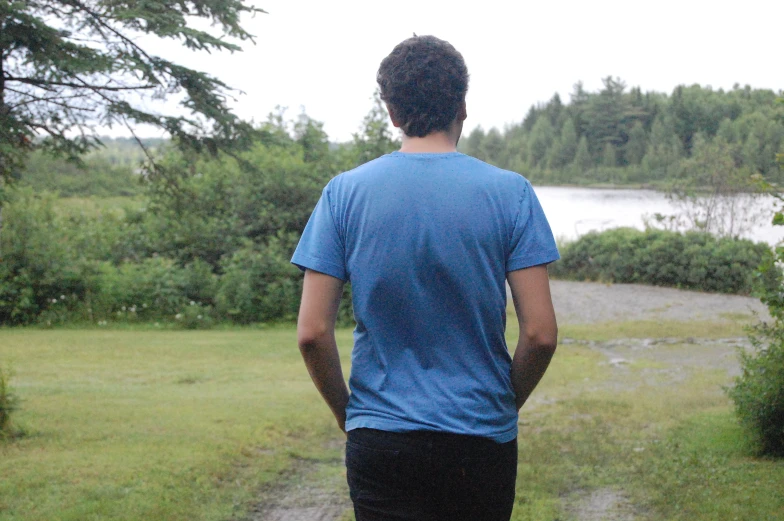 a man looks down the trail as he watches the water