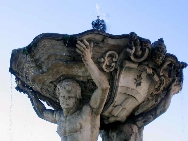 an artistic, old fountain features a statue holding the hand of god