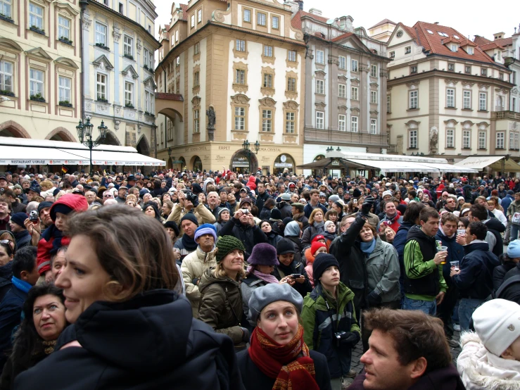 a huge group of people stand outside in the street