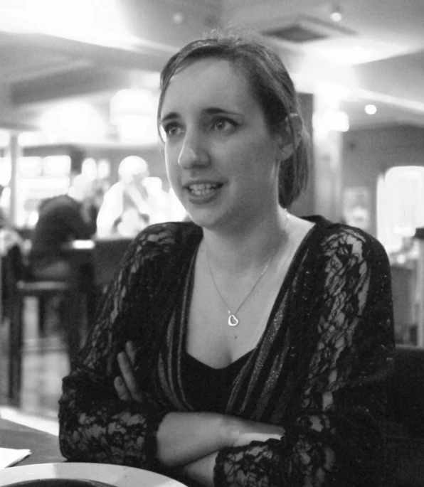 a black and white po of a woman sitting at a table