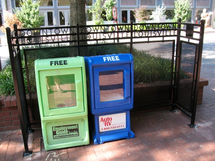 two cardboard boxes sit next to a fence