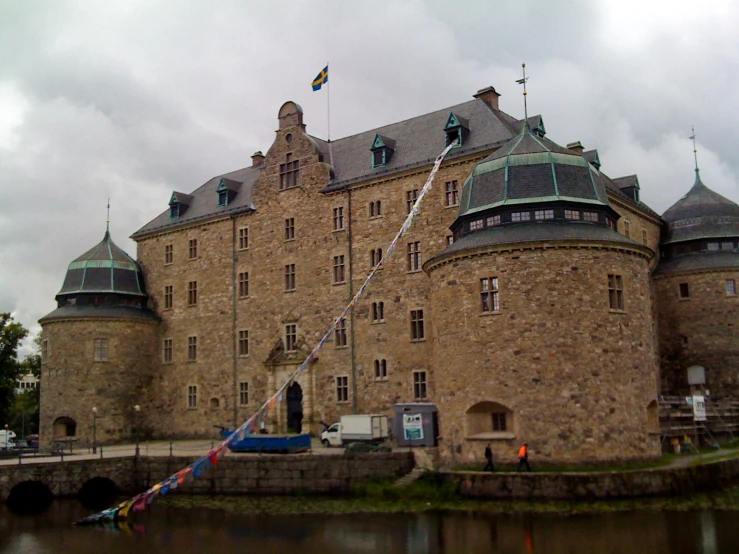 the water is calm in front of a stone castle