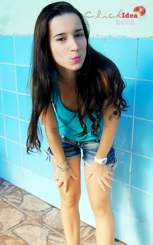 a young woman is in front of a blue wall with her  out