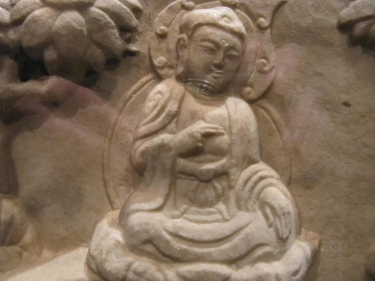 carvings of seated buddhas in a stucco wall