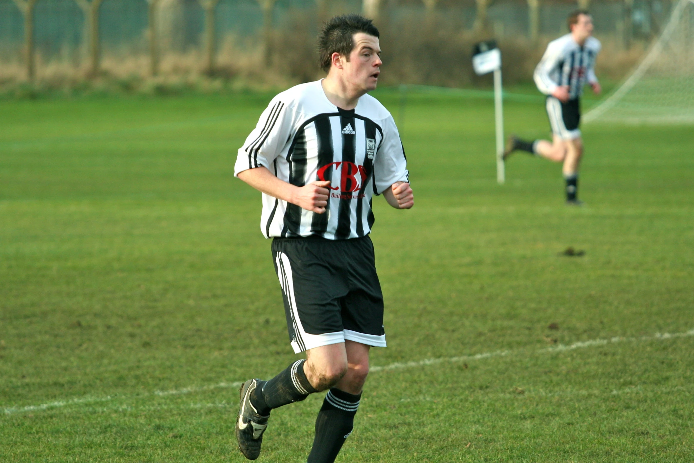 a young man is chasing a soccer ball while running