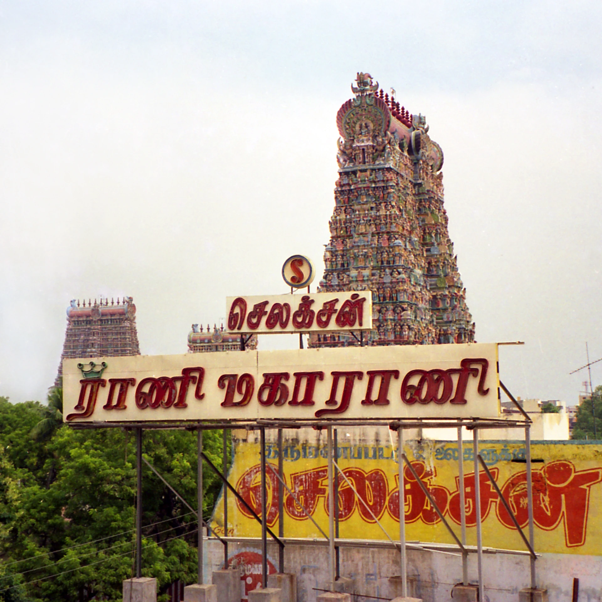 a small temple tower next to a banner for indian festival