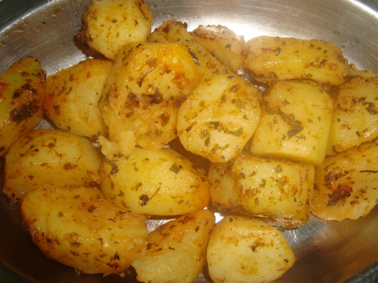 the cooked potatoes are in the pan with seasoning