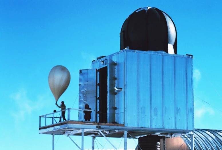 a couple of people standing on the roof of a large building