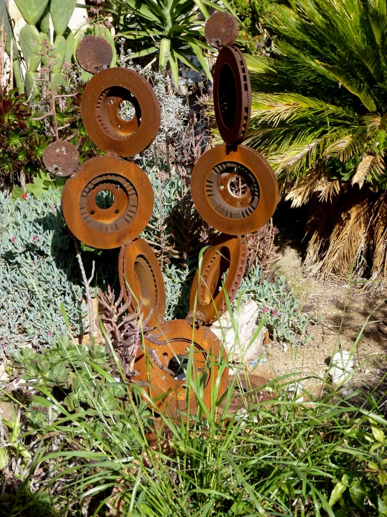 several large metal art pieces in a garden