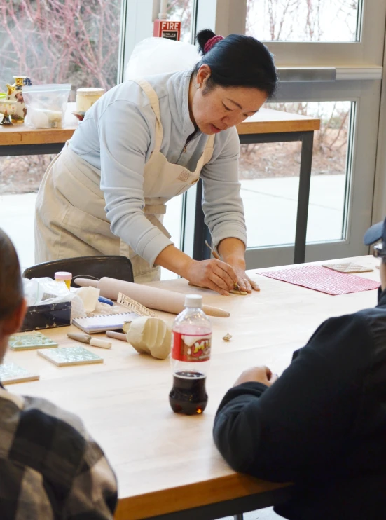 a woman cooking food at a restaurant table