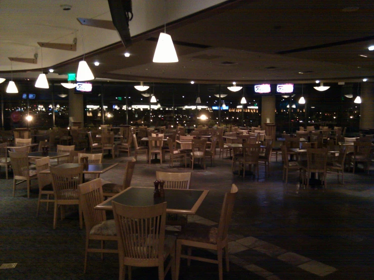 an empty dining room with tables and chairs and lights