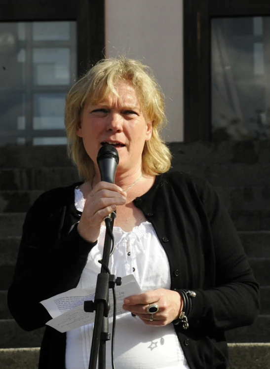 a woman singing into a microphone on a stage