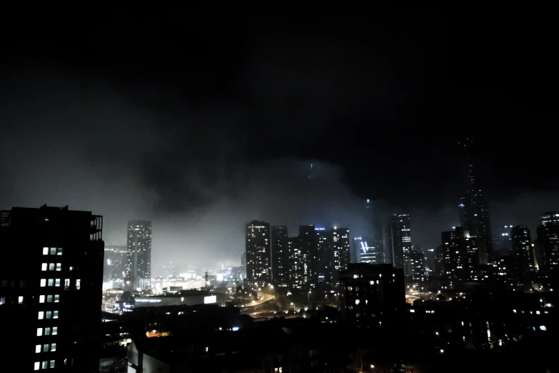 the cityscape is lit up at night by lots of clouds