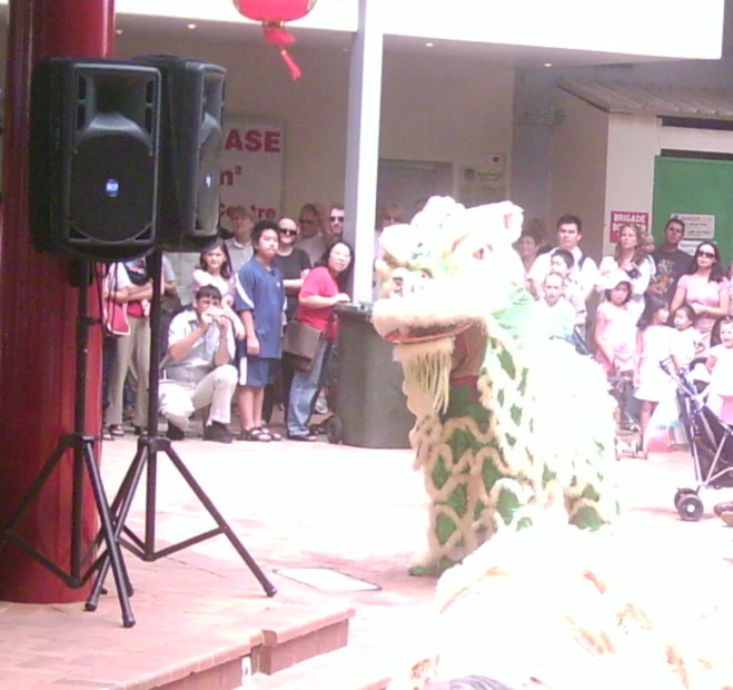 a green and white dragon and people watching