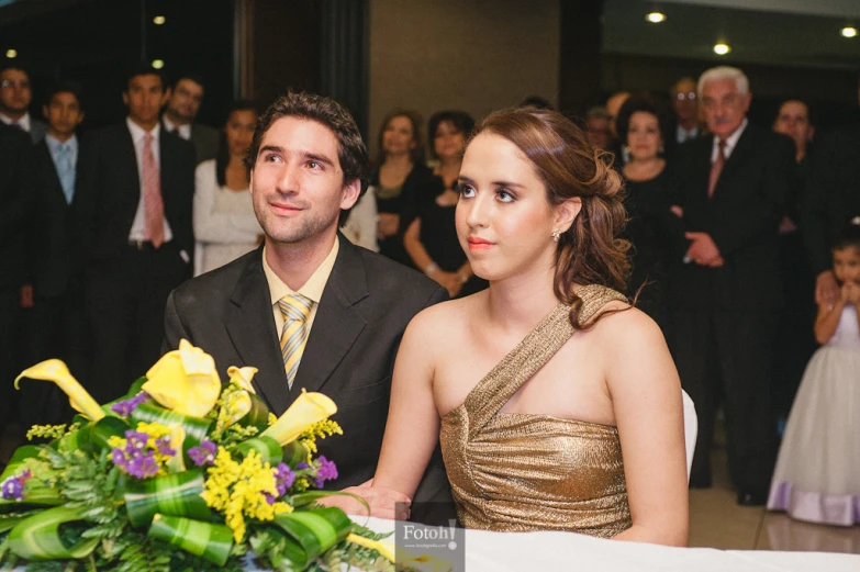 a man and woman sitting at a table in front of a group