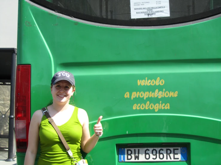 a woman in a green top holding up her thumb