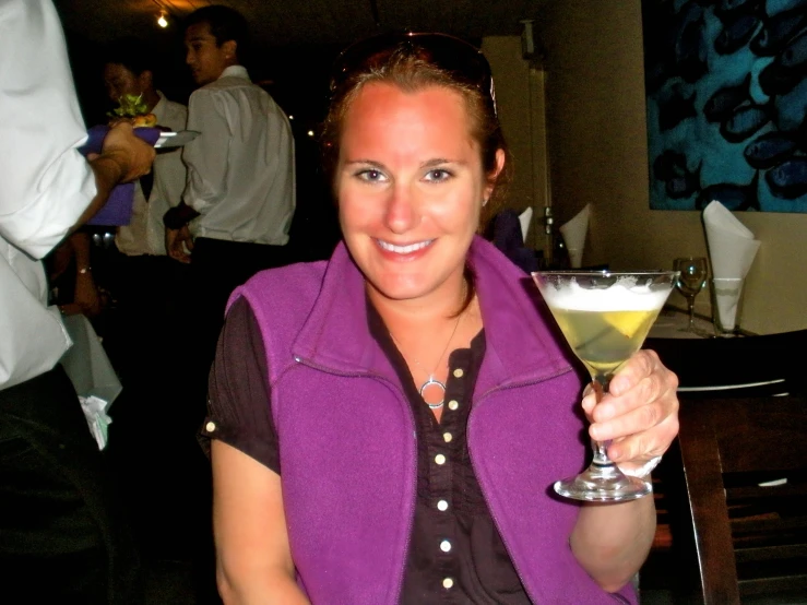 a lady wearing a vest holding a martini