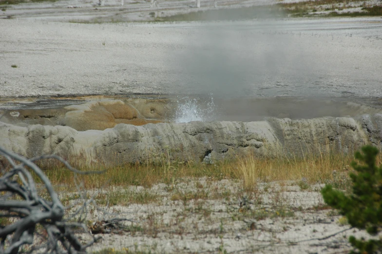 the steam is rising up out of the ground in the distance