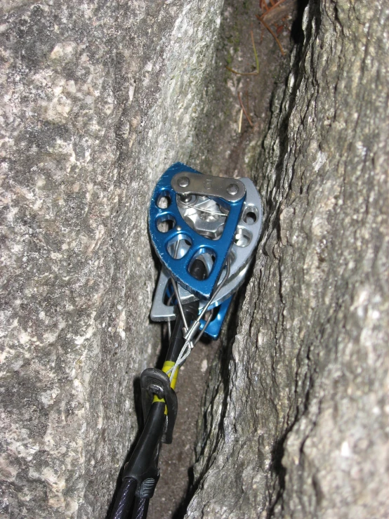 a rock climber holding onto a blue metal hook
