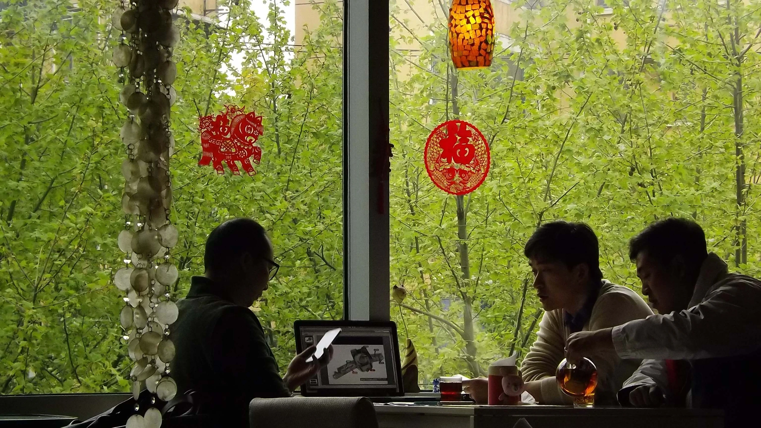 three people sit at a table at a restaurant